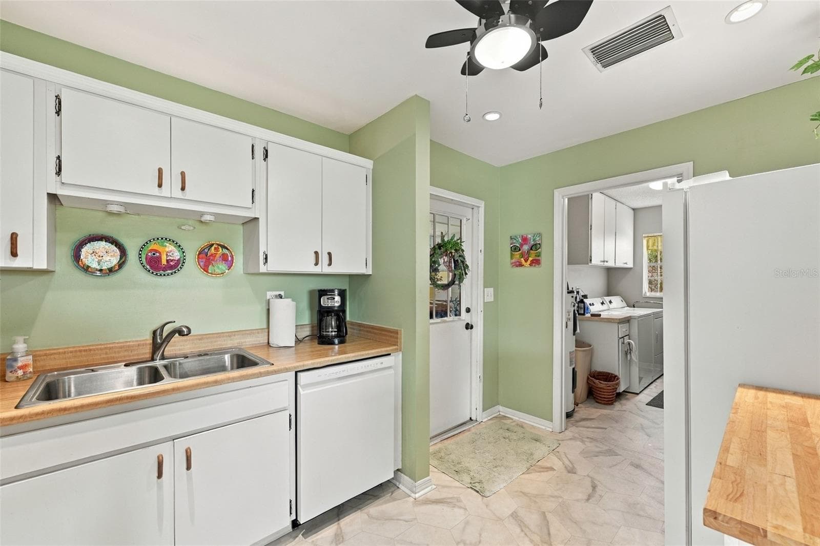 Simple all white cabinetry gives this room a sparkling clean appearance with bright recessed lights and a ceiling fan. - 215 GENET CT, SUN CITY CENTER