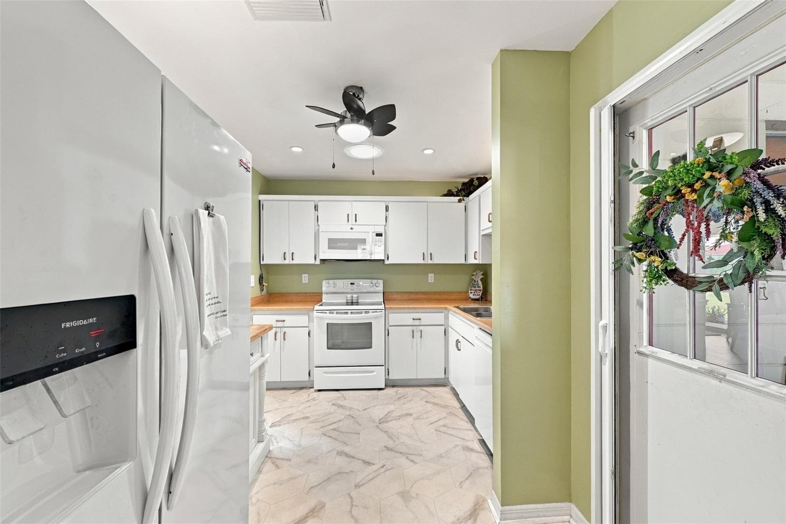 The kitchen is a very nice size and the door to the garage has a screen door attachment, so that you can open the garage door and let the sea breezes blow through the home. - 215 GENET CT, SUN CITY CENTER