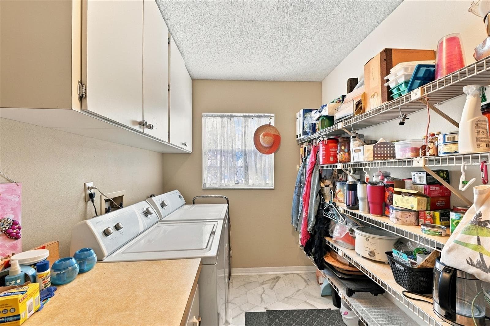 The inside laundry room has lots of storage and cabinetry with new windows for natural sunshine. - 215 GENET CT, SUN CITY CENTER