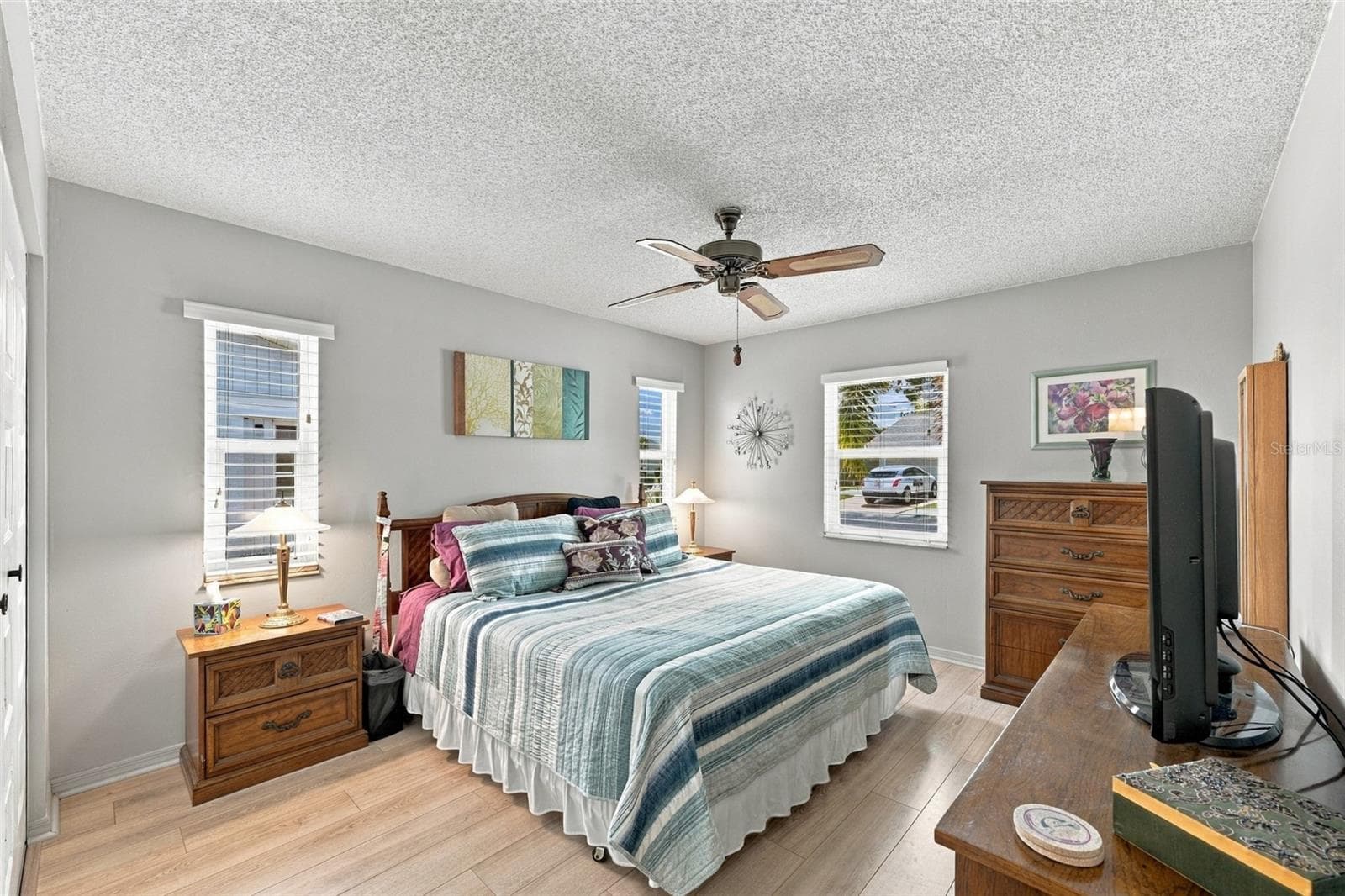 The primary bedroom is spacious with multiple windows and a muted paint tone for relaxation and comfort. - 215 GENET CT, SUN CITY CENTER