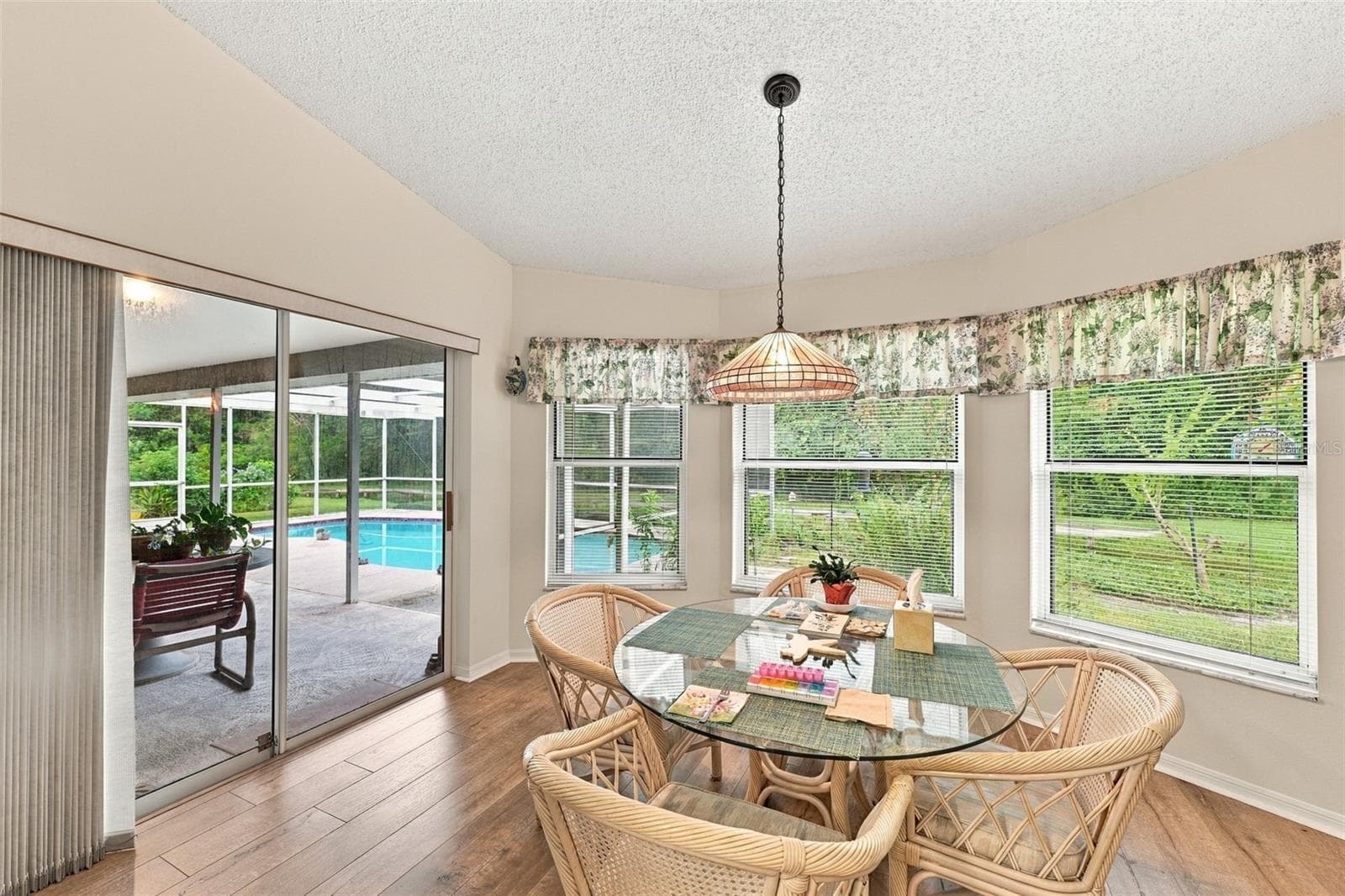 Kitchen nook with view of bird feeder, flower garden, access to pool area - 8657 CYPRESS LAKES BLVD, NEW PORT RICHEY