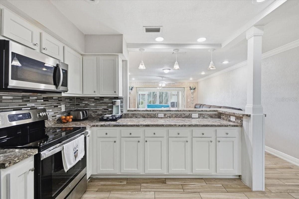 Kitchen view into Family Room and Sun Room - 1801 ORCHID CT, SUN CITY CENTER