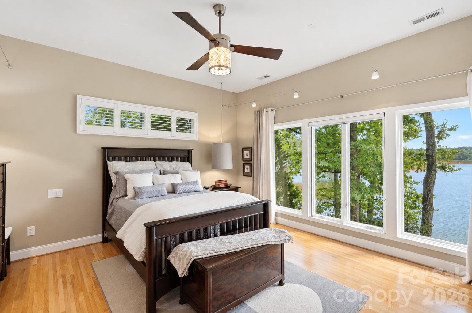 Main-level primary suite boasts two walk-in closets, and peaceful lake views - 1075 Lakefront Woods Drive, Belmont