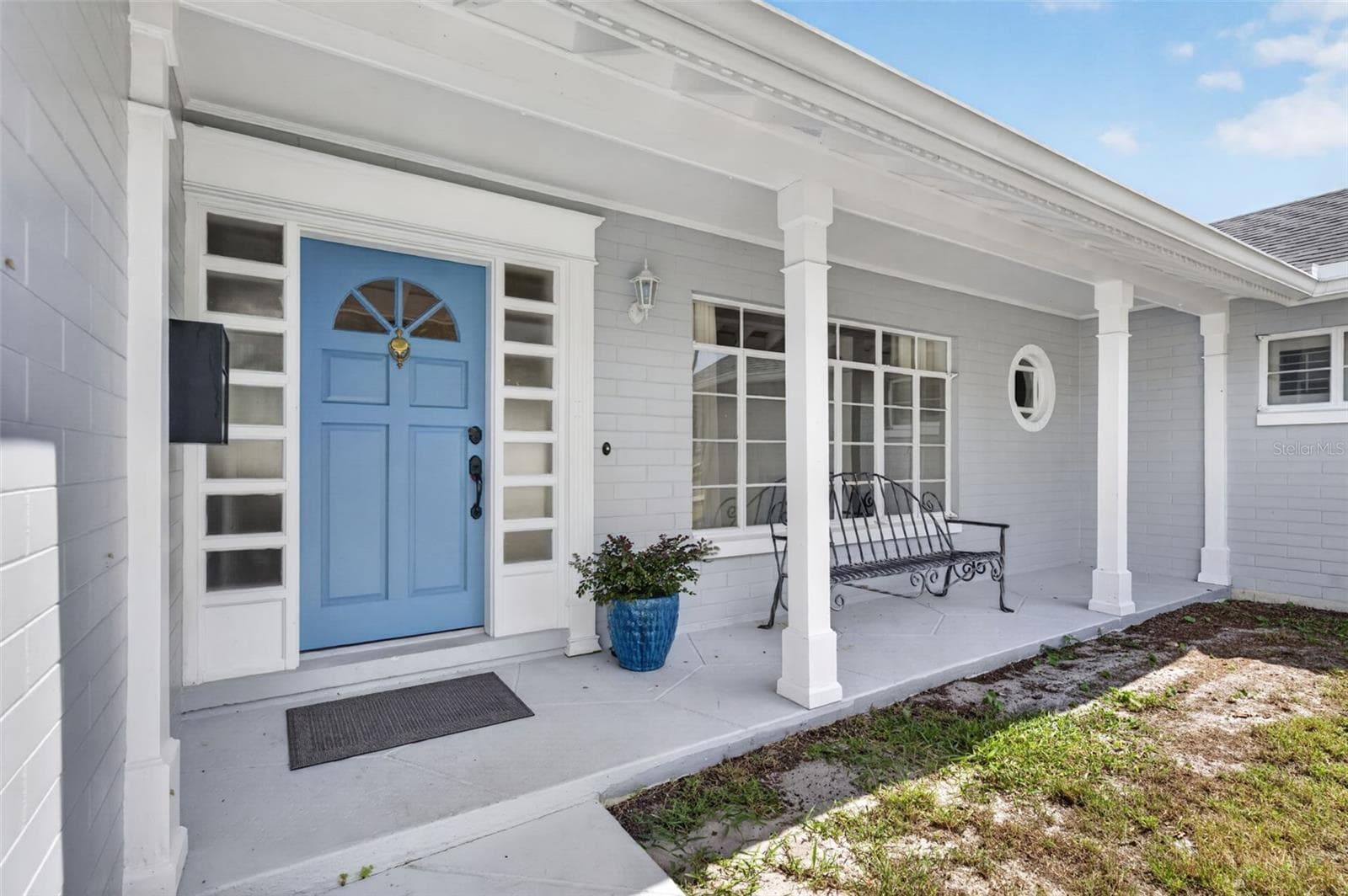 Covered Front Porch — Welcoming covered porch with a distinctive blue front door framed by detailed millwork and sidelights. - 200 SENECA TRL, MAITLAND