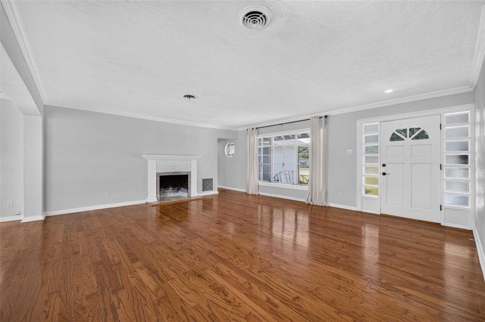 Living Area — Another view of the main living space highlighting the hardwood floors, fireplace, crown molding and natural light. - 200 SENECA TRL, MAITLAND