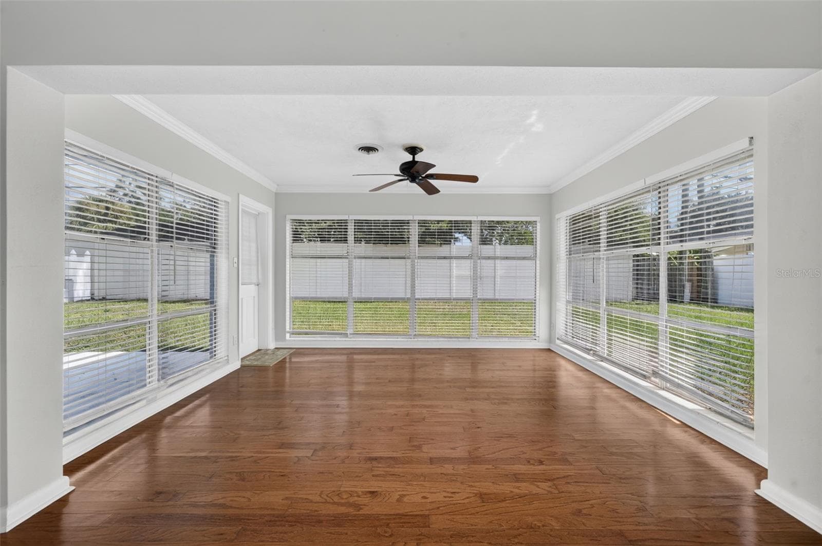 Florida Room — Light-filled Florida room with hardwood floors and expansive windows overlooking the backyard. - 200 SENECA TRL, MAITLAND