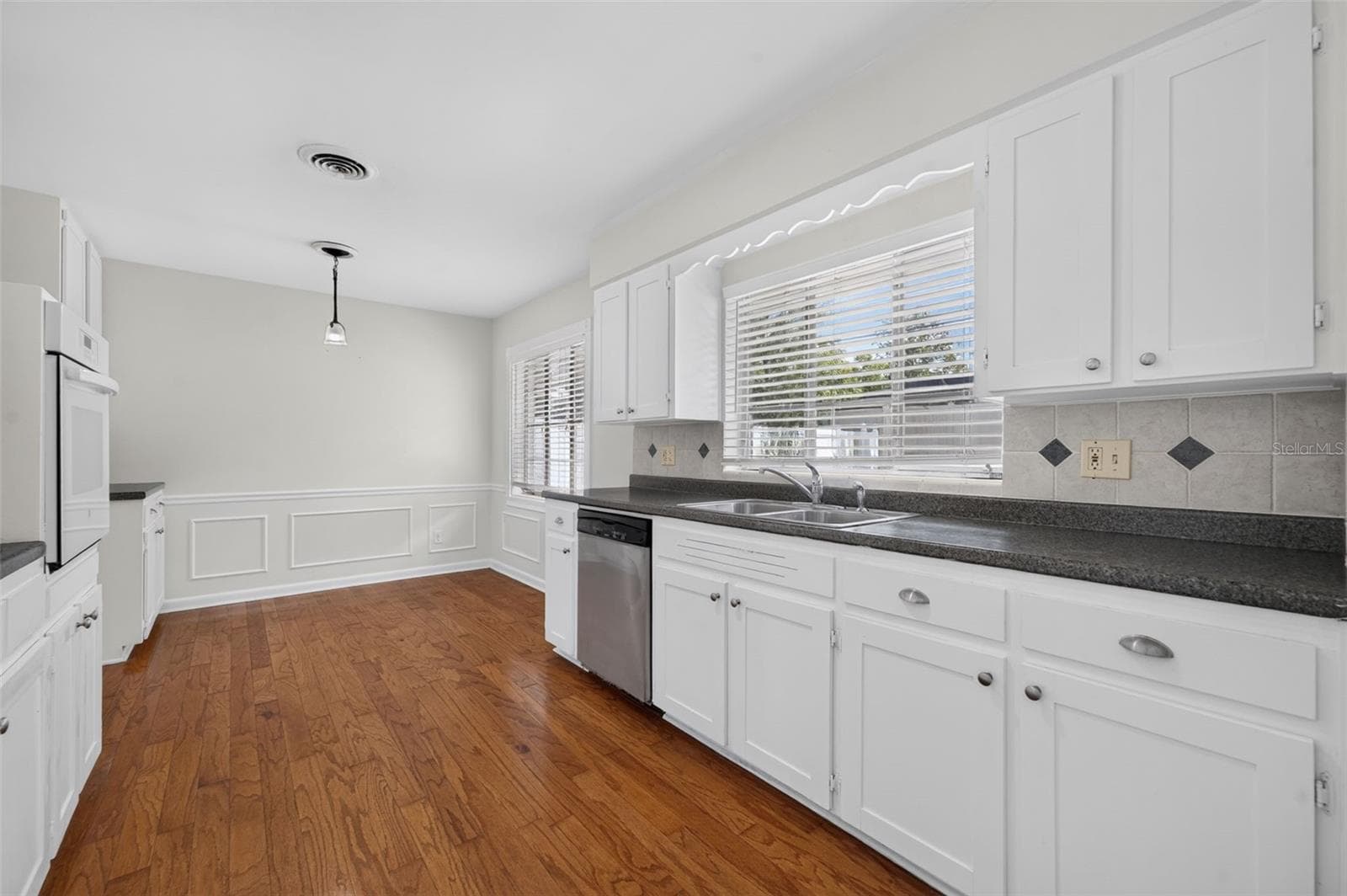 Kitchen — Charming kitchen retaining its original real-wood cabinetry, with a built-in oven, glass cooktop, stainless-steel dishwasher and hardwood flooring. - 200 SENECA TRL, MAITLAND