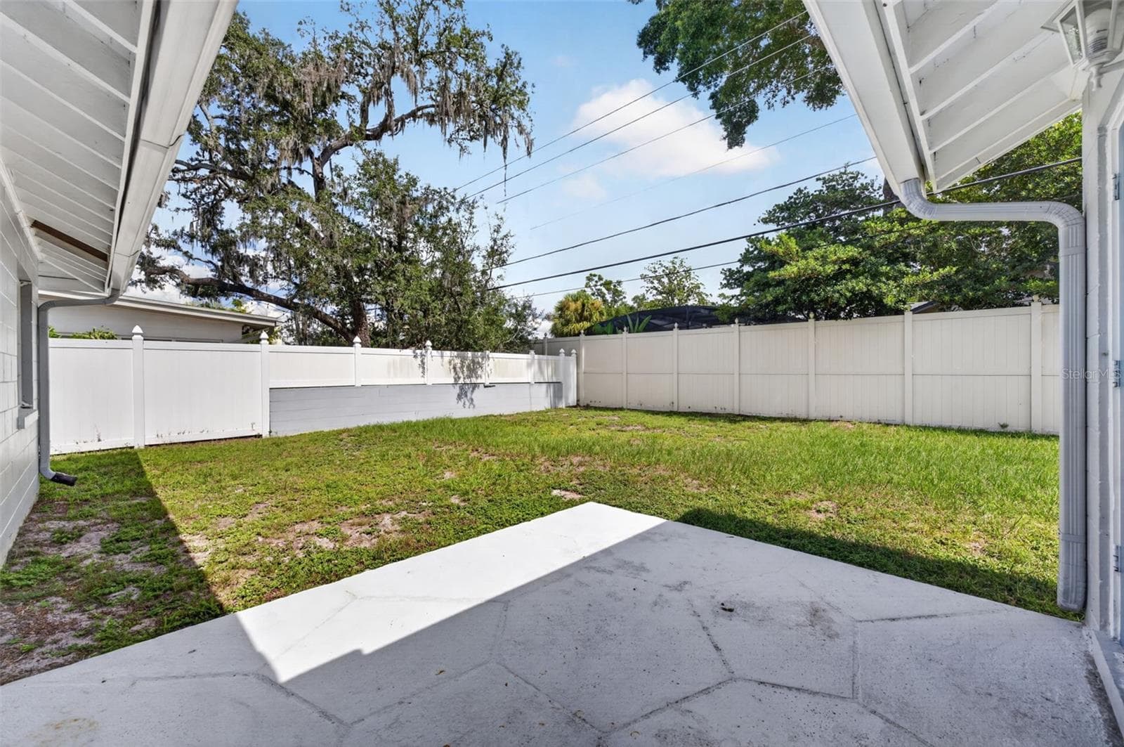 Covered Patio & Backyard — Covered rear patio opens to the spacious, almost fully fenced backyard. - 200 SENECA TRL, MAITLAND