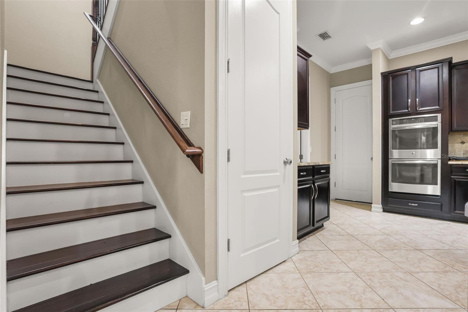 Stairs to 4 bedrooms and 3 bathrooms. To the right of the stairs is the pantry, laundry room and door leading to the 3 car garage - 1260 BELLA VISTA CIR, LONGWOOD