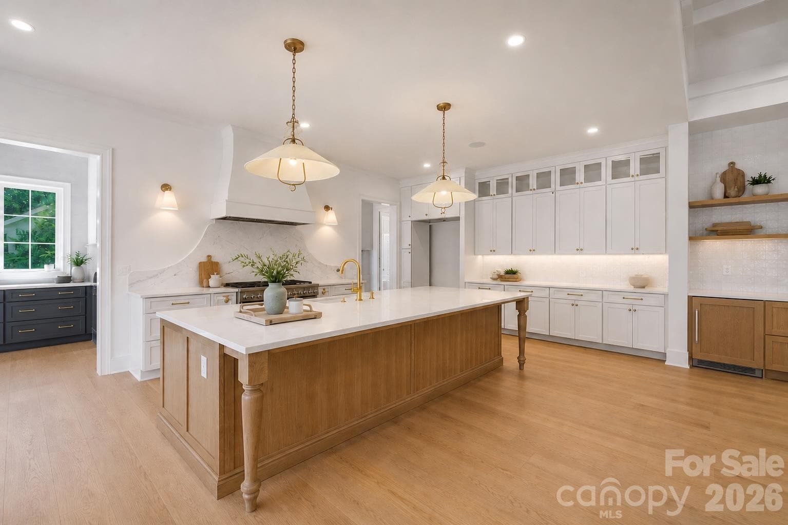 Custom kitchen with oversized island, under cabinet & statement lighting w/ a hospitality bar for guest - 125 Randstone Court, Charlotte