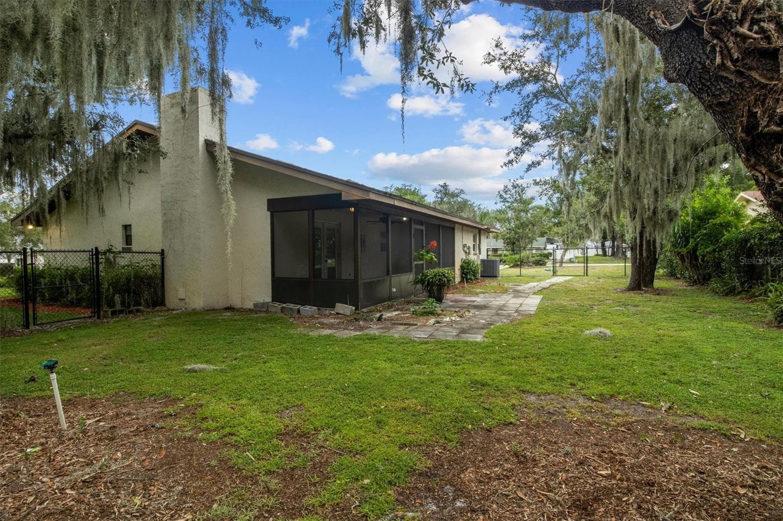 View from the backyard, beautiful mature Oak Trees and wonderful enclosed back patio - 4302 SHADOW WOOD LN, WINTER HAVEN