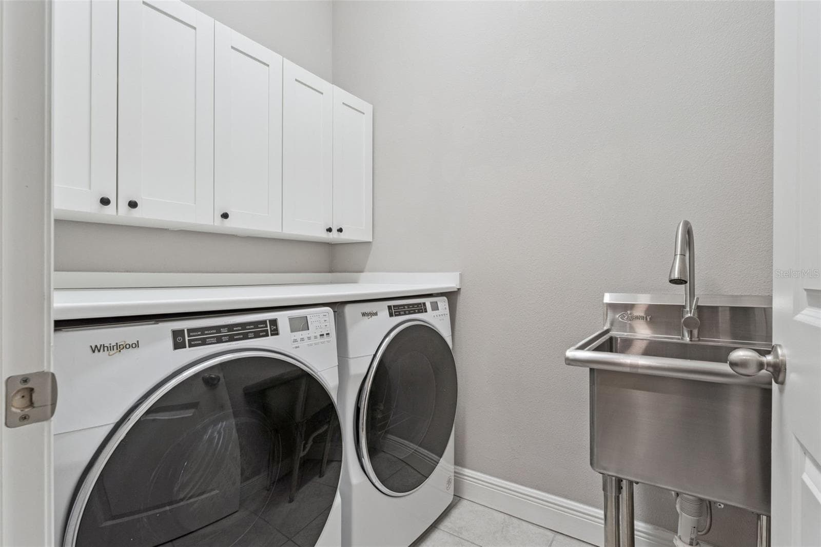 Convenient laundry room with upper cabinetry and space for full-size appliances. - 19058 PLANETREE ST, ORLANDO