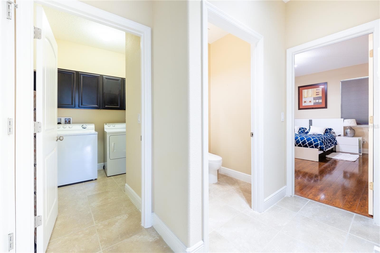 Main-floor hallway with laundry room and access to the primary suite - 3048 BOATING BLVD, KISSIMMEE