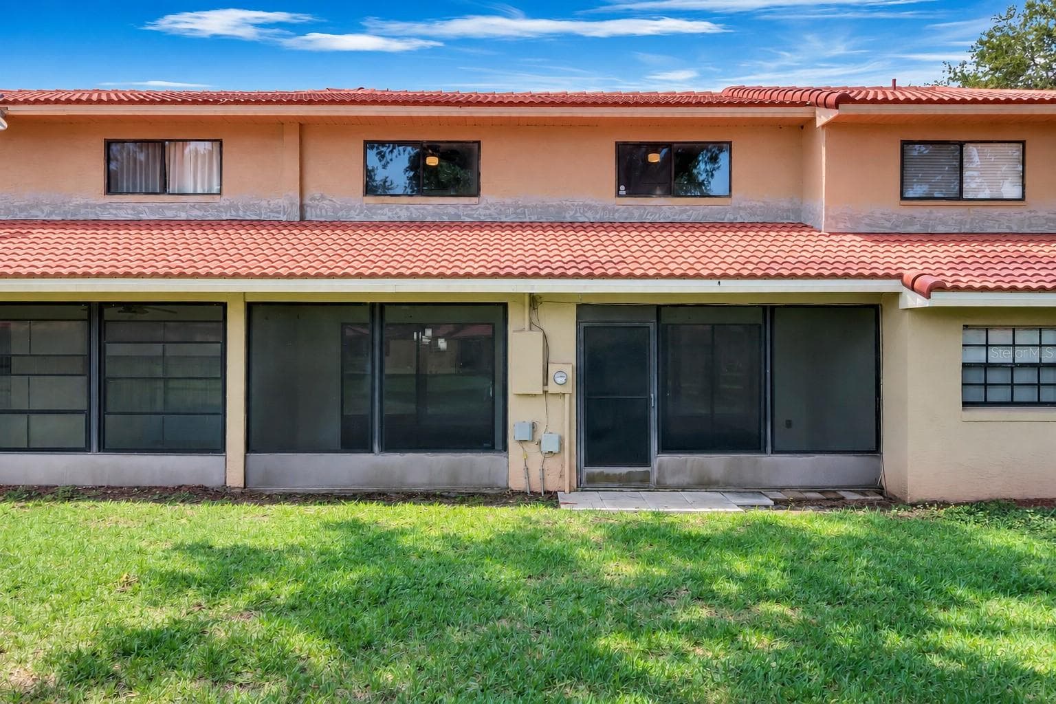 Screened lanai opens onto a shared green space. - 8235 AMBROSE COVE WAY, ORLANDO