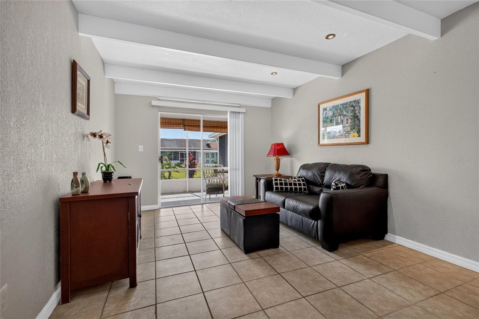 The living room is 11' x 14' with a sliding glass door that opens to the back screened porch. - 4409 CLUB CIR, LAKE WALES