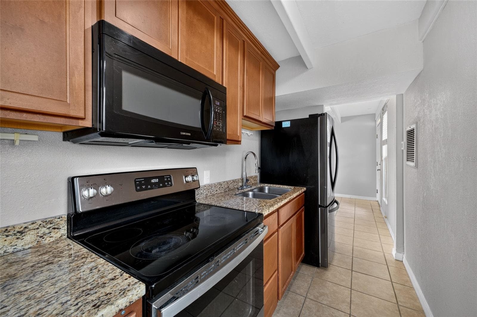 Granite Countertops. Stainless steel / black kitchen appliances including a built in microwave. - 4409 CLUB CIR, LAKE WALES