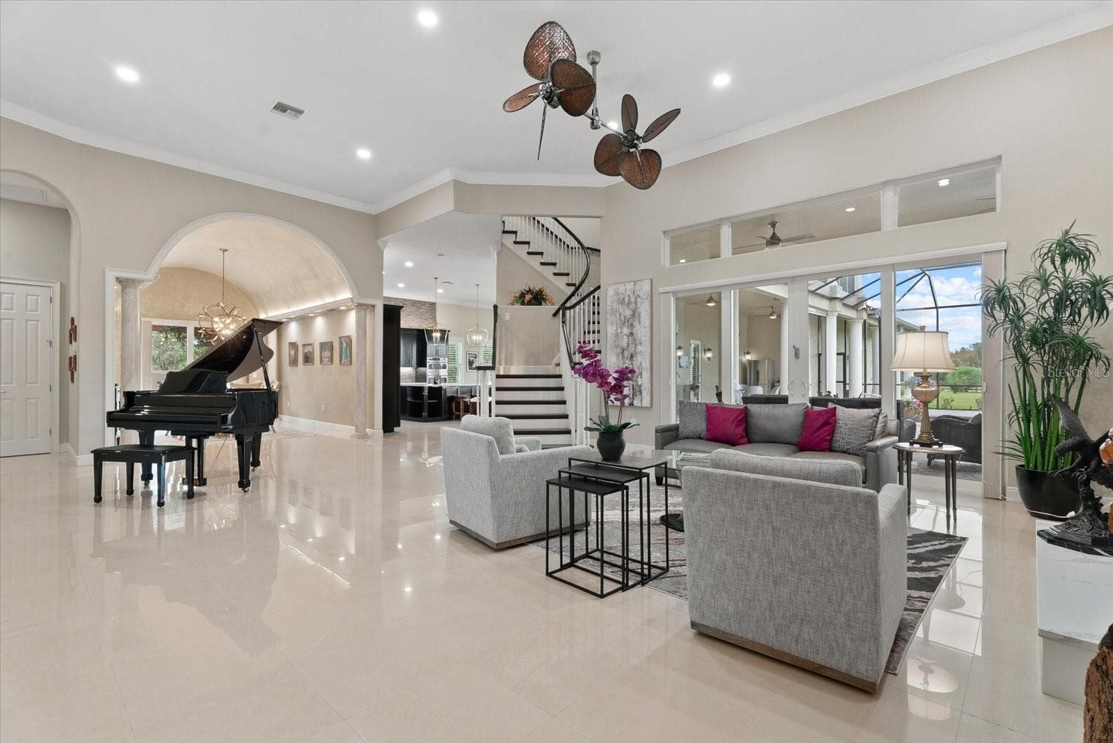 Sparkling tile floors, 12 ft ceilings, crown molding, clerestory windows, a winding staircase and custom wood trim set the tone for this wonderful front living room - 520 RYE RD NE, BRADENTON