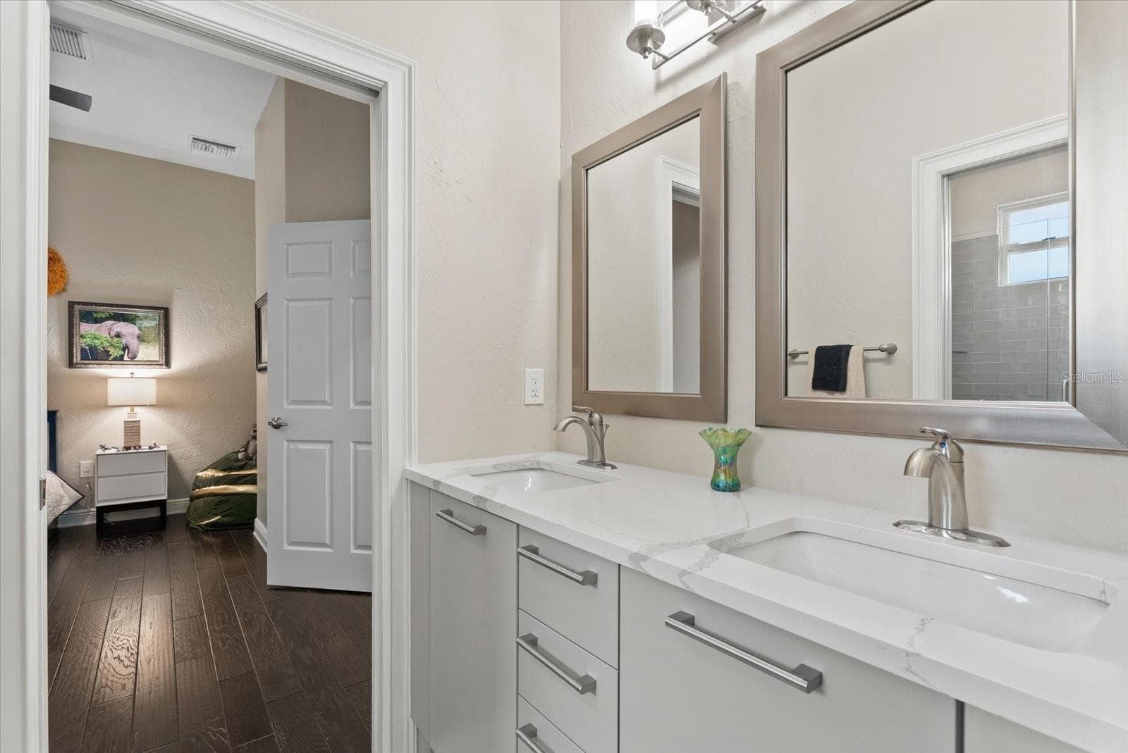 A Jack and Jill bathroom connects bedrooms three and fout, offering dual sinks and mirrors - 520 RYE RD NE, BRADENTON