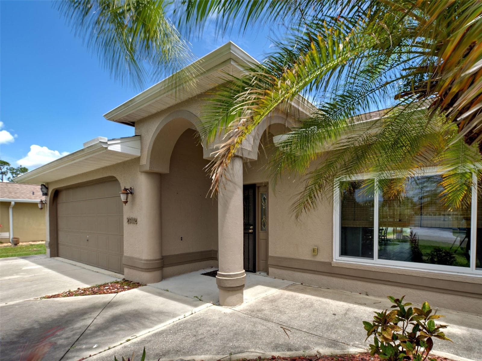The architectural details around the front door enhance the elegance of this home. - 23102 MADELYN AVE, PORT CHARLOTTE