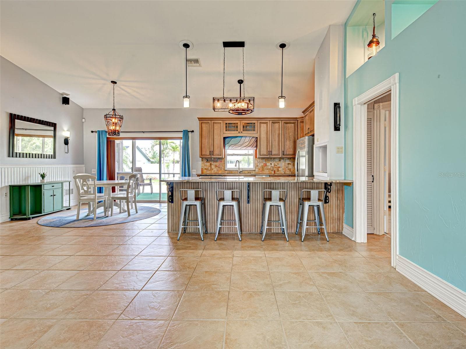 The dining area is steps away from the kitchen and has access to the lanai through the sliding glass doors. Look at the beautiful light fixtures. - 23102 MADELYN AVE, PORT CHARLOTTE