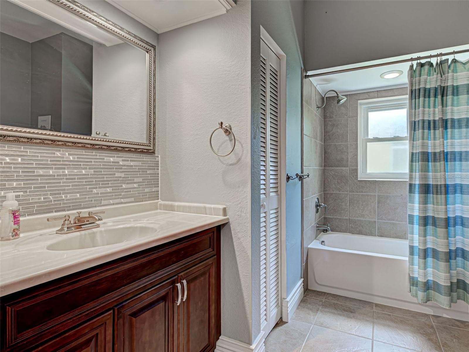 A beautiful backsplash provides the perfect touch for the guest bathroom. - 23102 MADELYN AVE, PORT CHARLOTTE