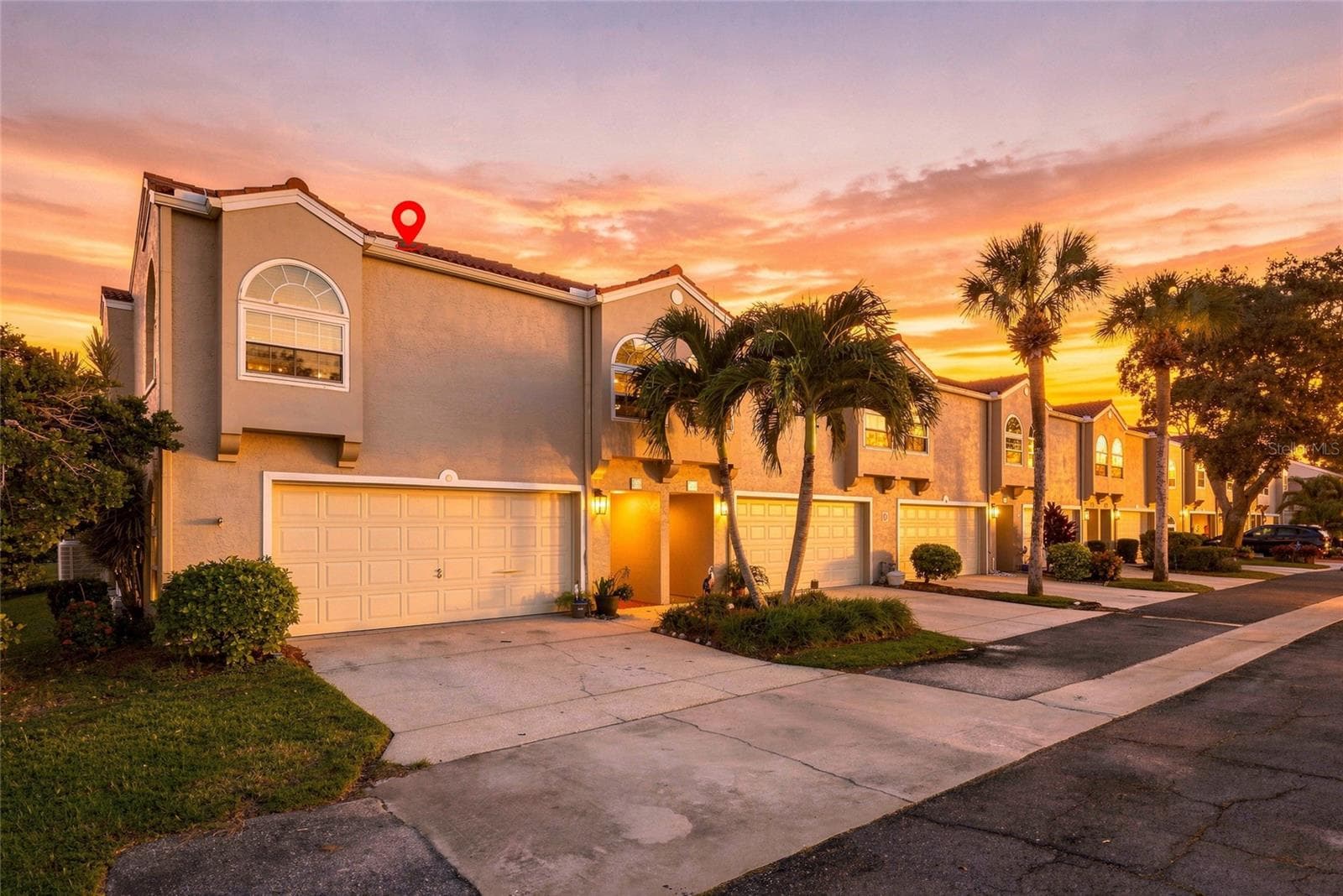 Beautiful twilight view showcasing the home’s desirable corner setting and inviting exterior. - 629 SEGOVIA CT NE #405, ST PETERSBURG