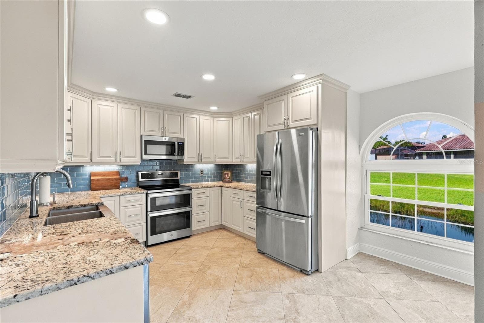 Beautifully updated kitchen featuring striking Norwegian Blue granite countertops and warm Alabama maple cabinetry. - 629 SEGOVIA CT NE #405, ST PETERSBURG