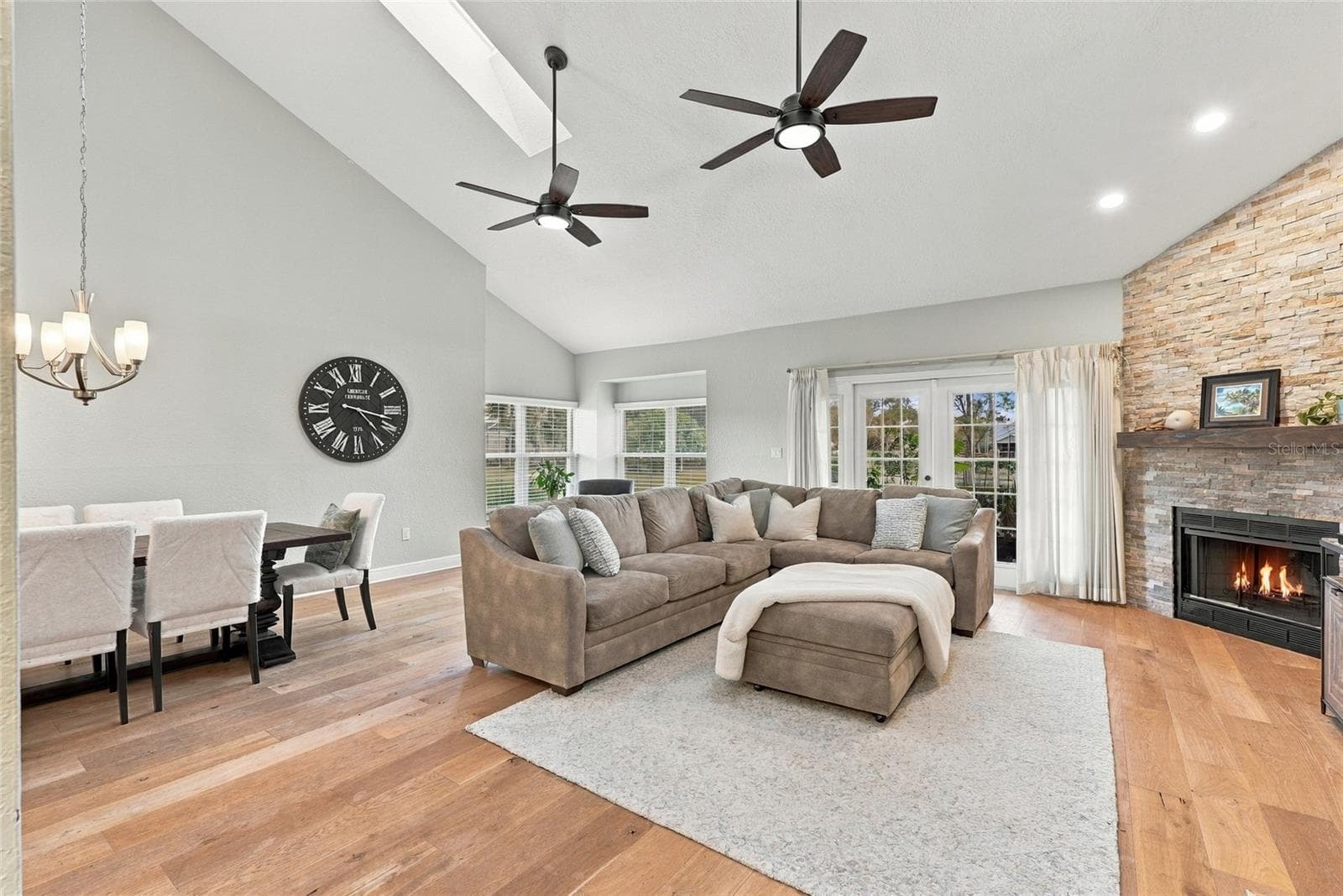 Expansive living area featuring beautiful hardwood floors, abundant natural light, and peaceful pond views. - 629 SEGOVIA CT NE #405, ST PETERSBURG