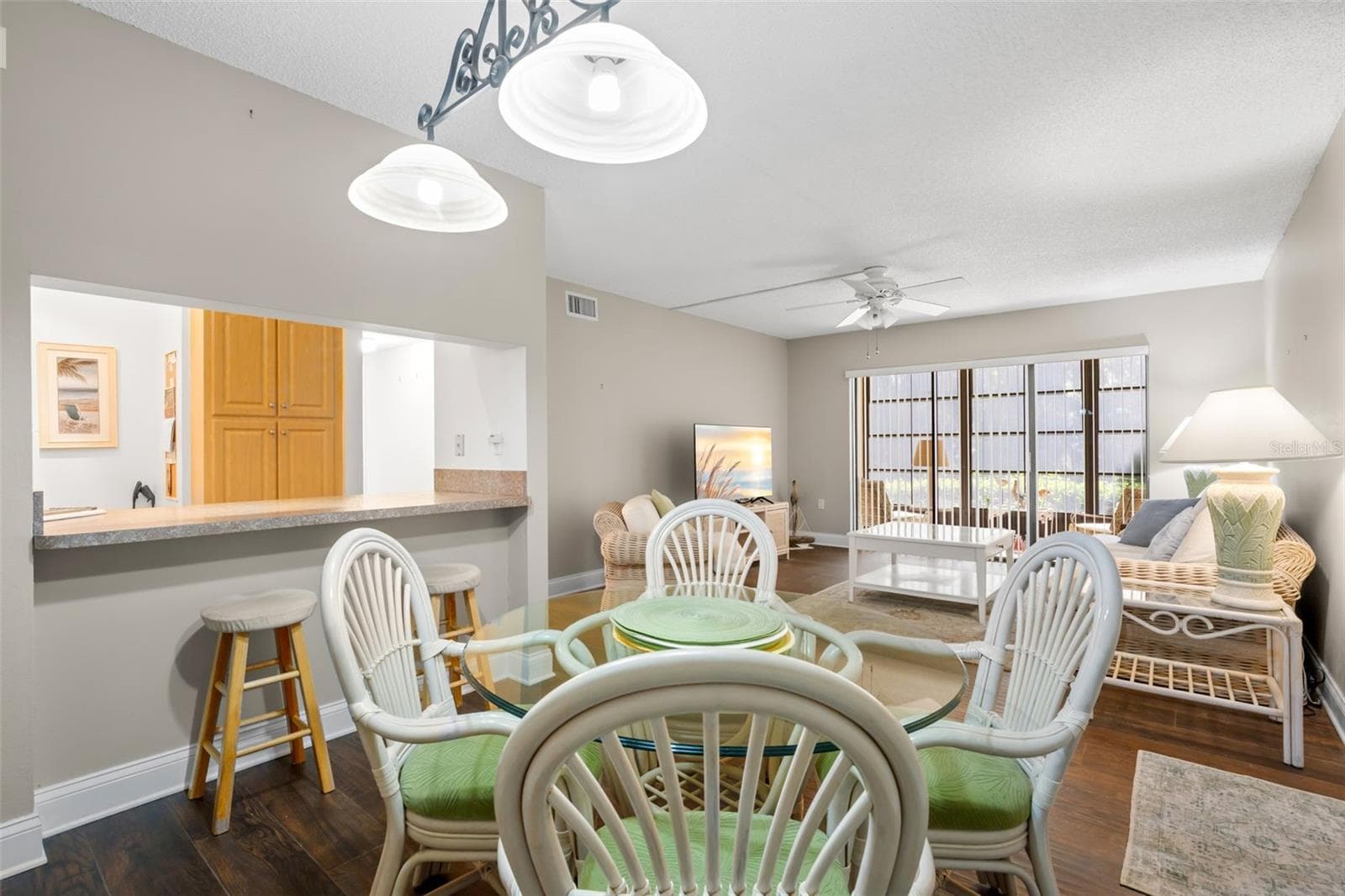 A decorative two-light fixture defines the dining area, while the wide kitchen pass-through adds extra counter space and keeps the kitchen connected to the living space. - 3188 LAKE PINE WAY S #F1, TARPON SPRINGS