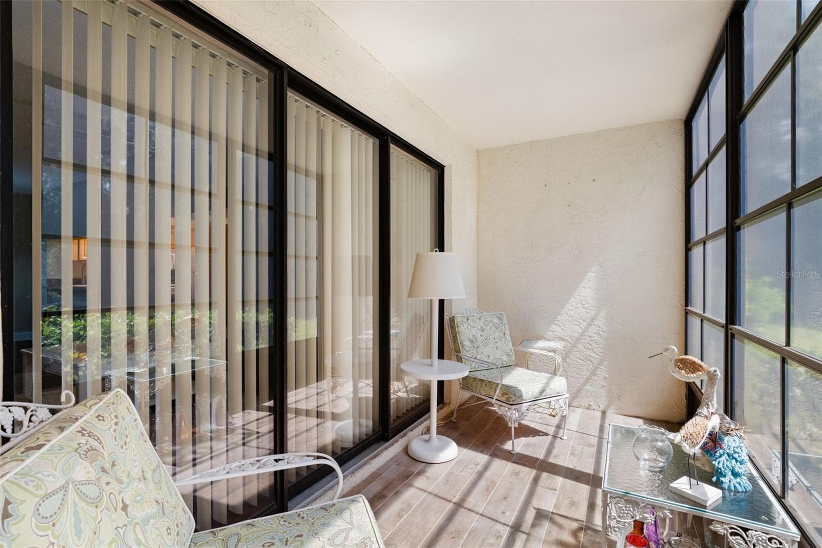 Sliding glass doors connect the living room directly to the screened lanai, making this a natural extension of the indoor space for reading, morning coffee, or simply enjoying the preserve-side setting. - 3188 LAKE PINE WAY S #F1, TARPON SPRINGS