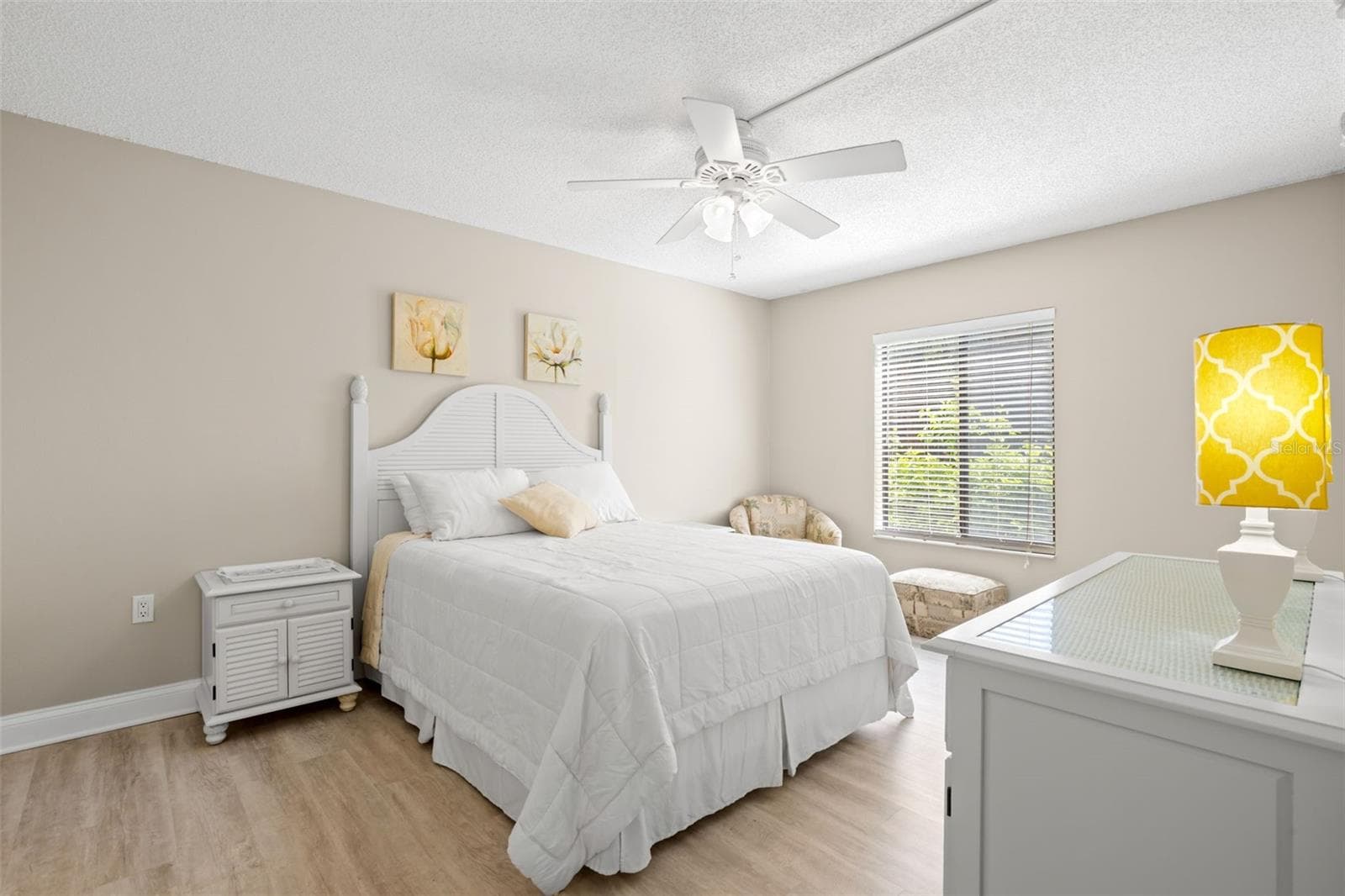 The primary bedroom continues the home’s neutral color palette, with a ceiling fan, soft natural light, and plenty of room for a full bedroom suite. - 3188 LAKE PINE WAY S #F1, TARPON SPRINGS