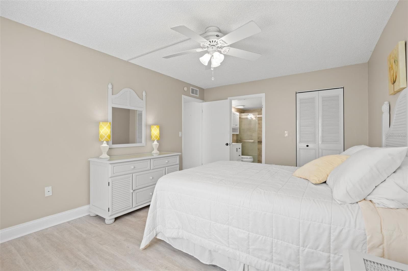 The primary suite includes direct access to the updated bath and a large walk-in closet, adding both privacy and practical storage. - 3188 LAKE PINE WAY S #F1, TARPON SPRINGS