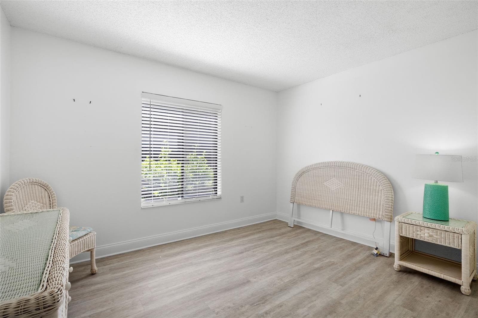 The second bedroom is bright and versatile, with light-toned flooring, a large window, and enough space to serve comfortably as a guest room, home office, or both. - 3188 LAKE PINE WAY S #F1, TARPON SPRINGS