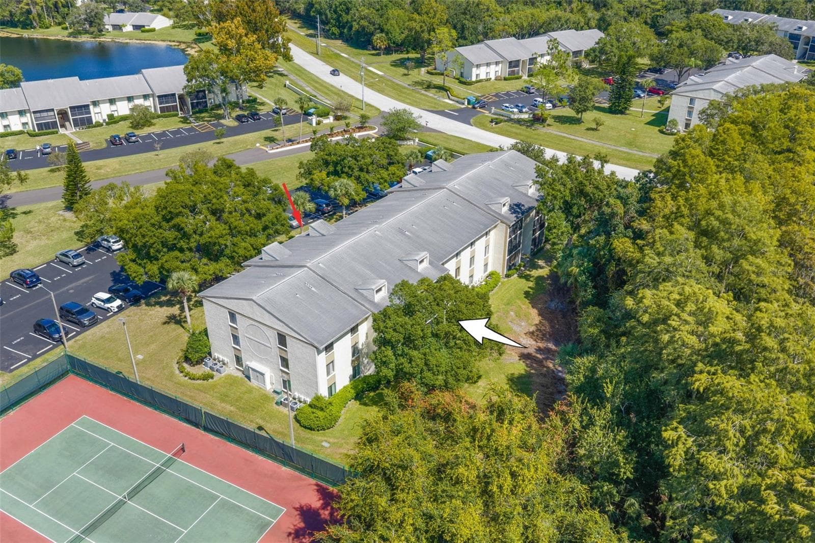 The condo enjoys a tucked-away setting along Brooker Creek Preserve, with tennis courts nearby and mature trees and open green space surrounding the community. - 3188 LAKE PINE WAY S #F1, TARPON SPRINGS