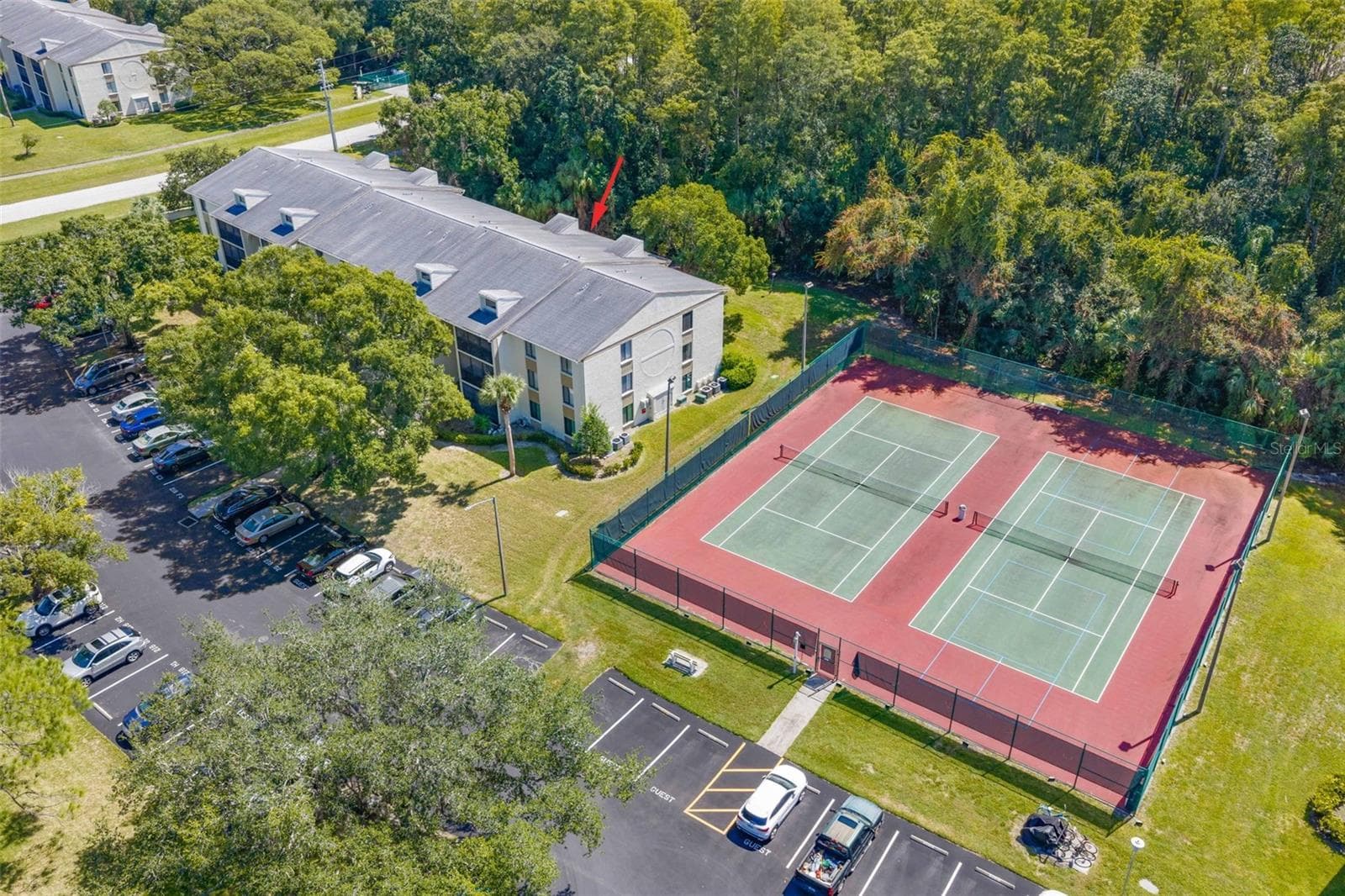 Building 218 is  tucked beside the community tennis courts, with Brooker Creek Preserve creating a lush natural backdrop behind the property. - 3188 LAKE PINE WAY S #F1, TARPON SPRINGS