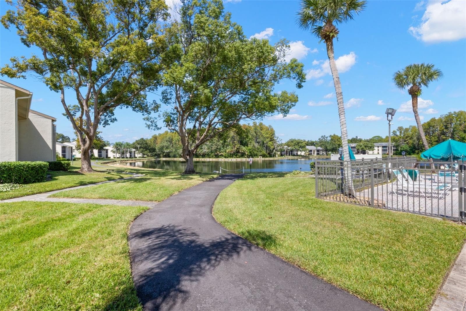 Paved walking paths wind through the community’s landscaped grounds and around the lake, offering an easy way to enjoy the scenery just beyond the pool. - 3188 LAKE PINE WAY S #F1, TARPON SPRINGS
