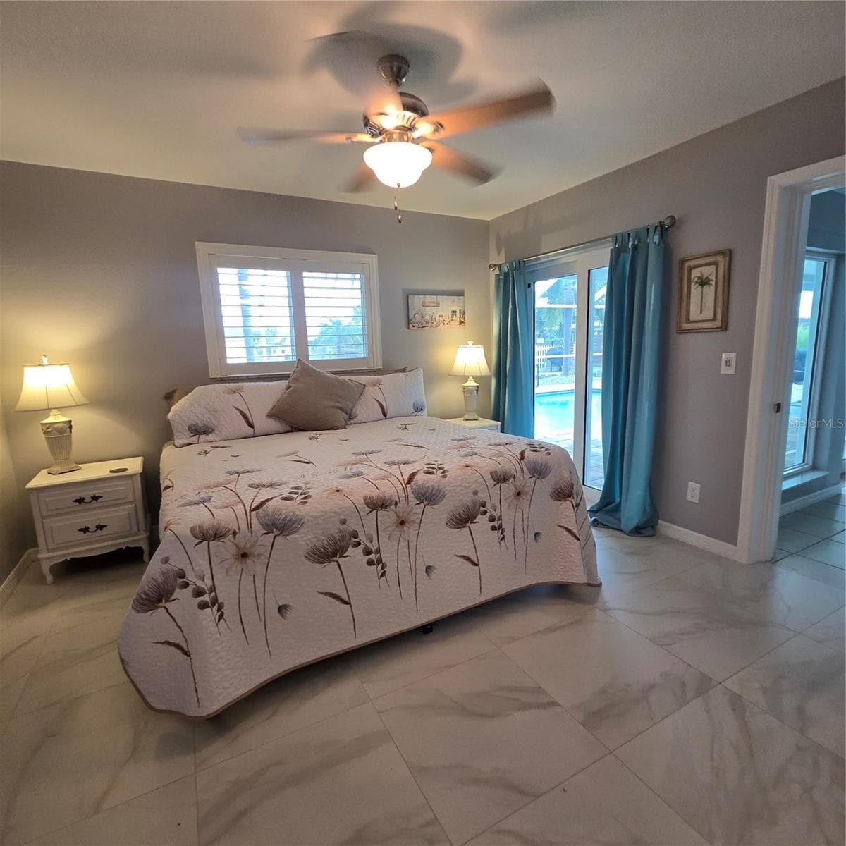 Primary bedroom showing off the hurricane impact sliding door to lanai & pool - 1433 LEMON BAY DR, ENGLEWOOD
