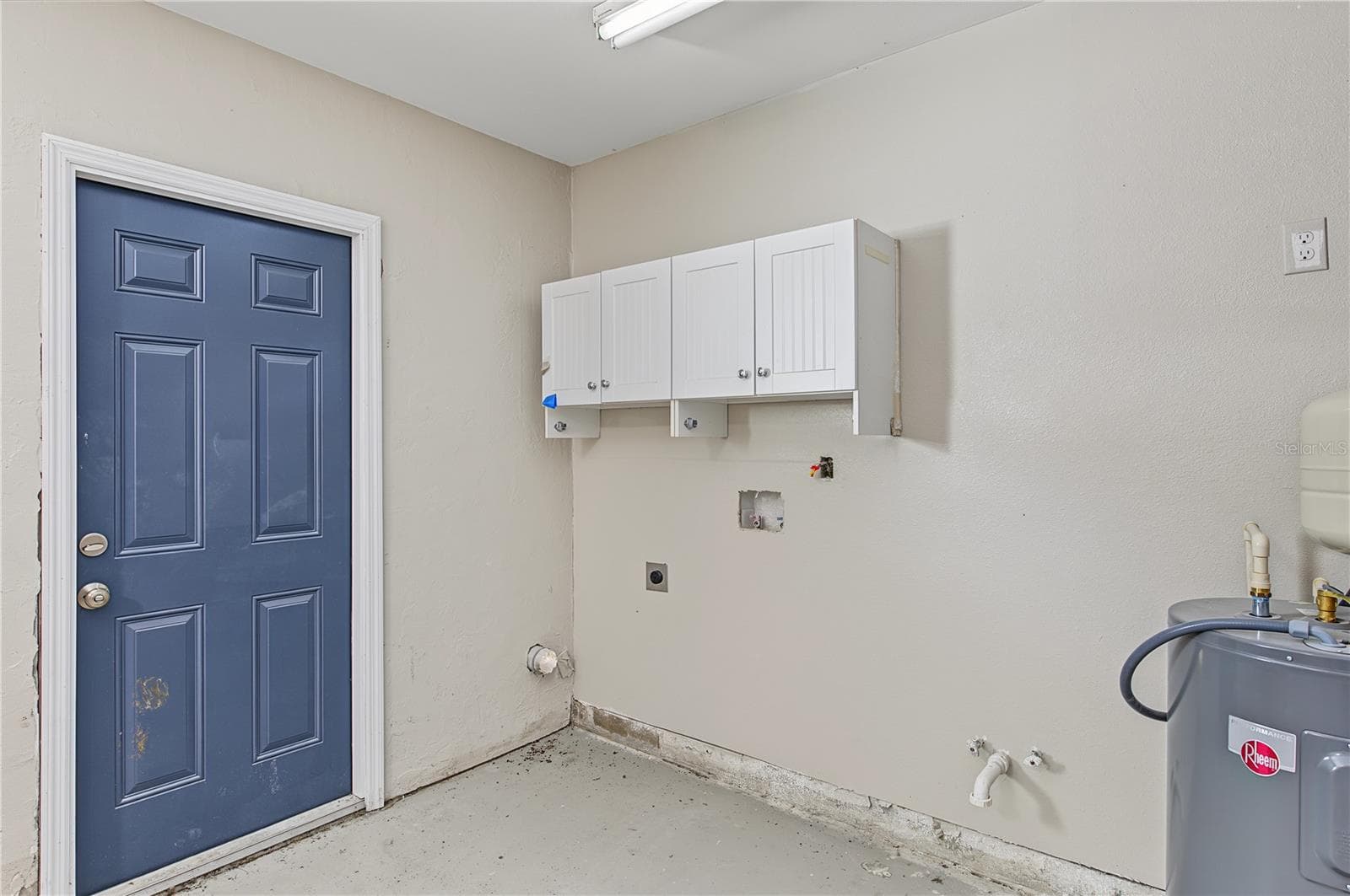 Dedicated laundry area with overhead storage cabinetry and convenient exterior access. - 260 SE 16TH TER, CRYSTAL RIVER