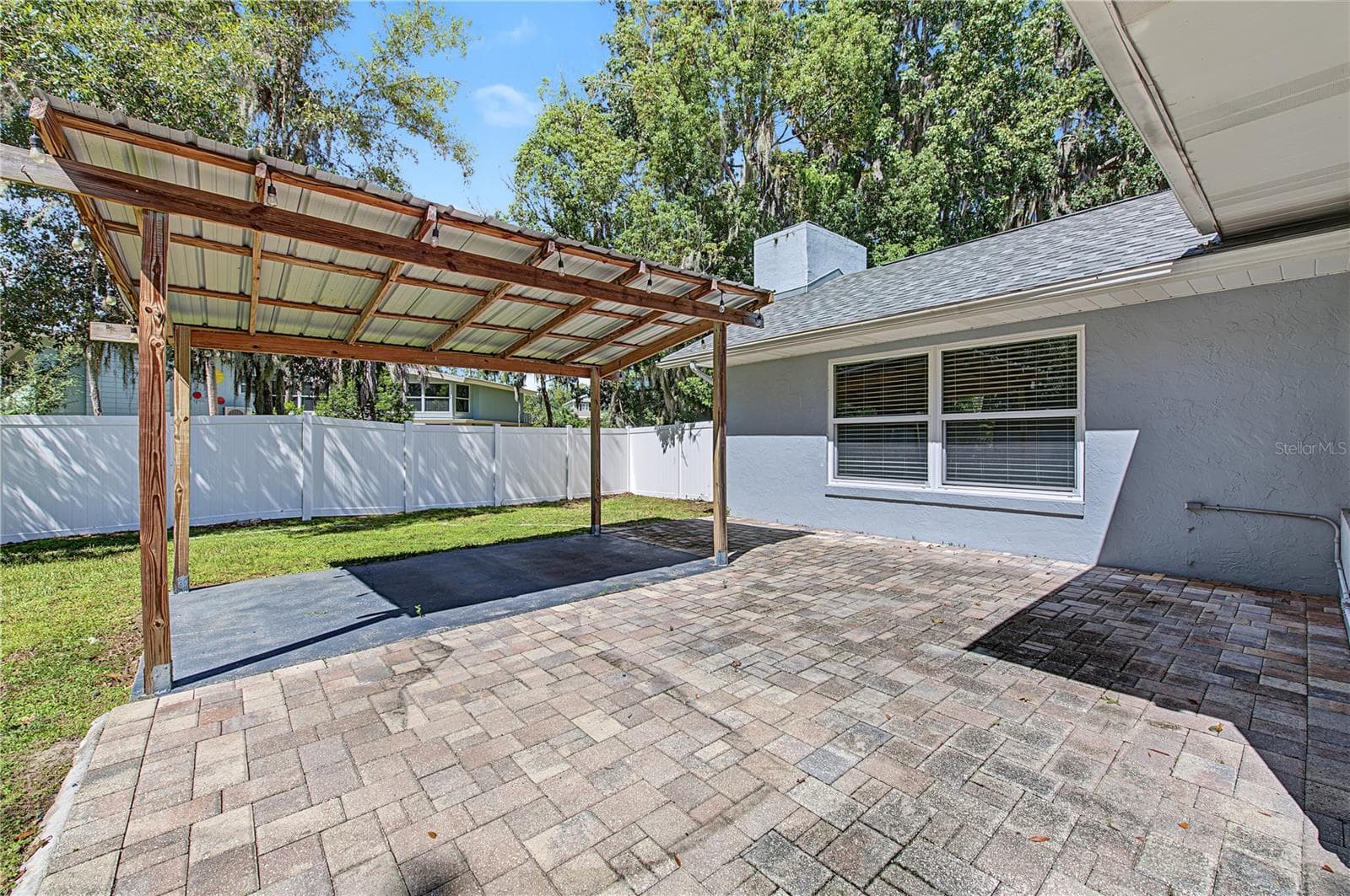 Spacious paved patio featuring a pergola-style structure and direct access to the home. - 260 SE 16TH TER, CRYSTAL RIVER