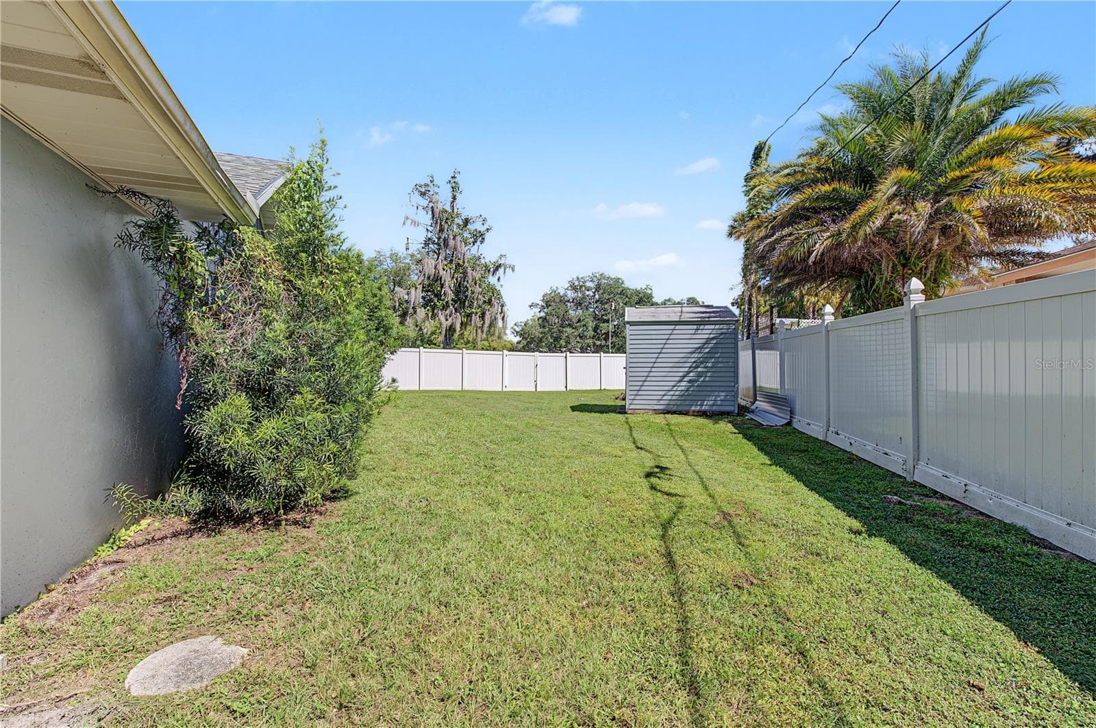 Side yard featuring established landscaping, grassy space, and a privacy-style fence. - 260 SE 16TH TER, CRYSTAL RIVER