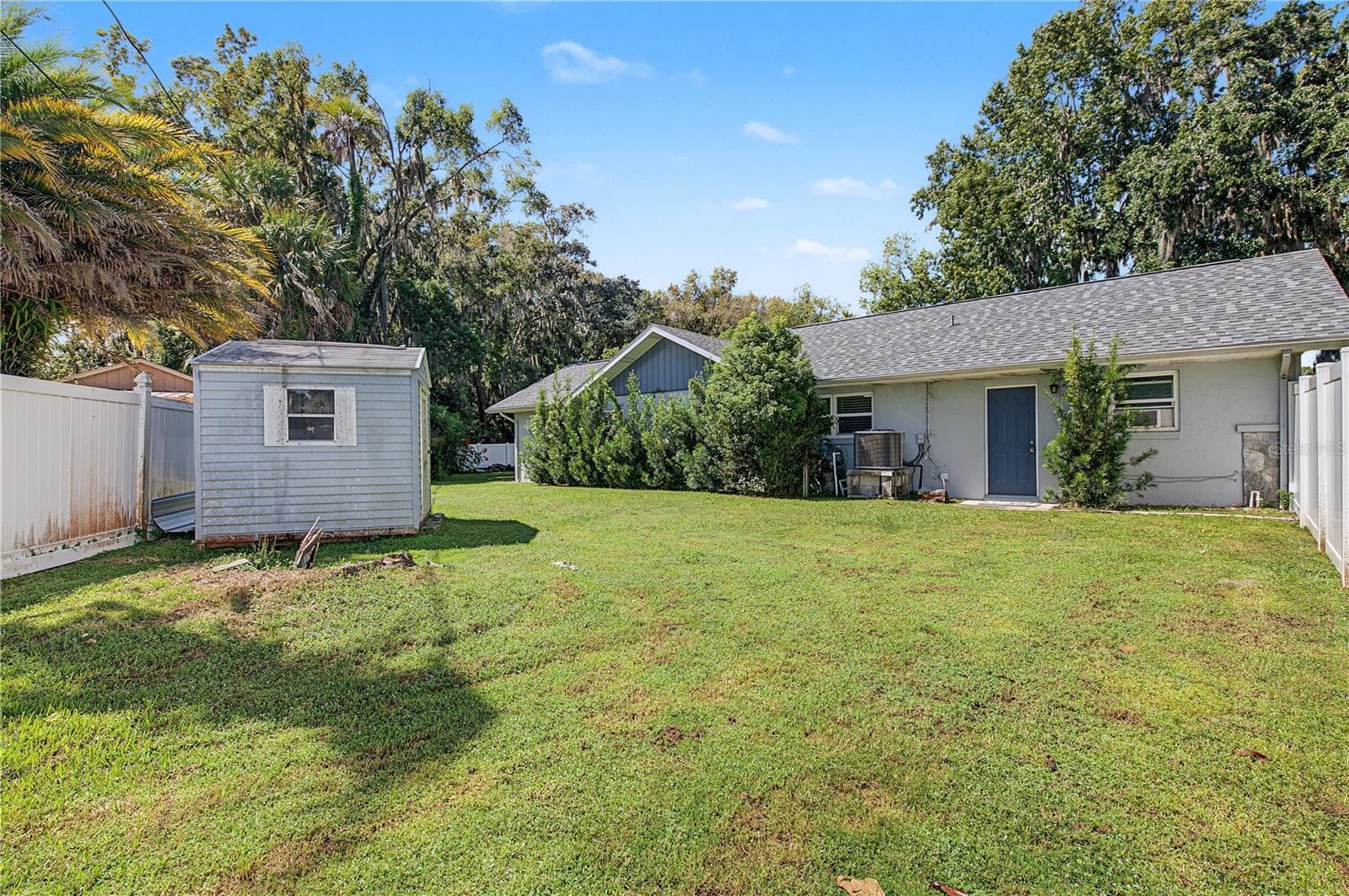 Additional backyard perspective showcasing the detached storage shed and surrounding green space. - 260 SE 16TH TER, CRYSTAL RIVER