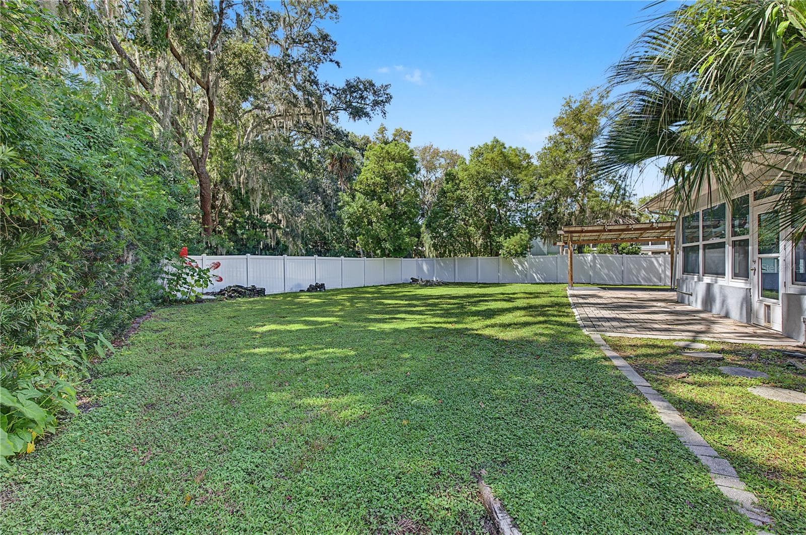 Wide-angle view highlighting the expansive lawn, mature landscaping, and rear exterior of the home. - 260 SE 16TH TER, CRYSTAL RIVER
