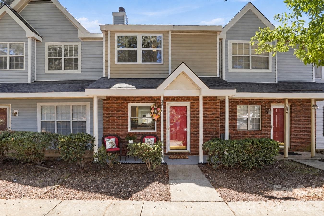 A covered front porch offers a charming spot to relax beside the home’s classic brick exterior. - 3858 Mosscroft Lane, Charlotte