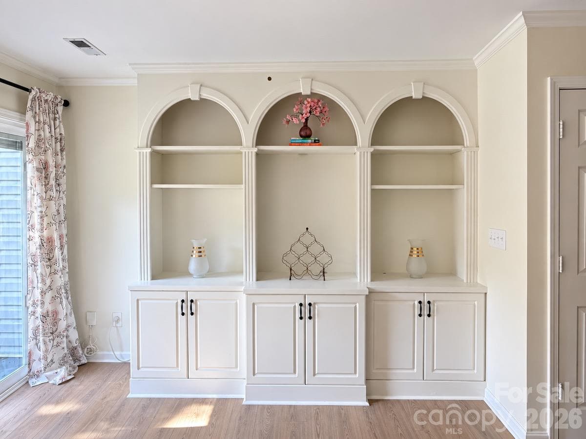 Distinctive arched built-ins offer space to display favorite pieces and keep everyday essentials tucked away. - 3858 Mosscroft Lane, Charlotte