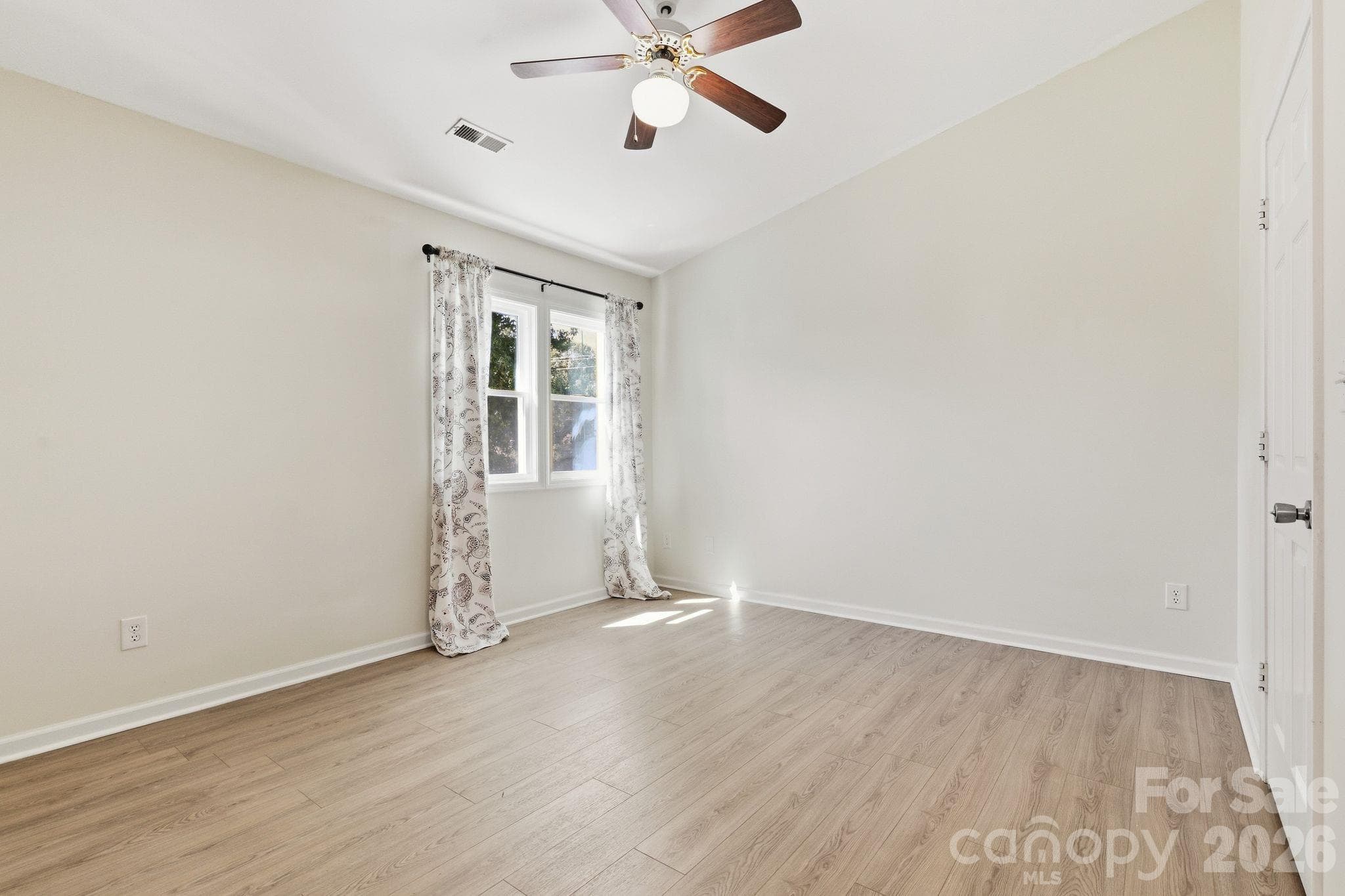 A welcoming guest bedroom offers a comfortable space for overnight visitors or flexibility for a home office. - 3858 Mosscroft Lane, Charlotte