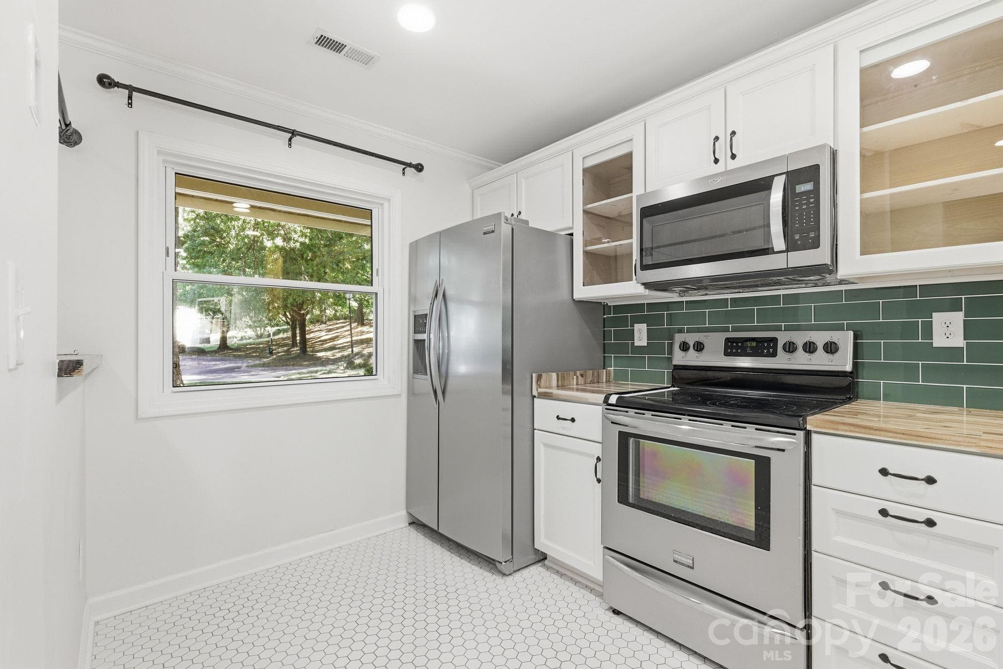 Fully renovated kitchen featuring handmade cabinetry, new countertops, and a farmhouse sink. - 3858 Mosscroft Lane, Charlotte