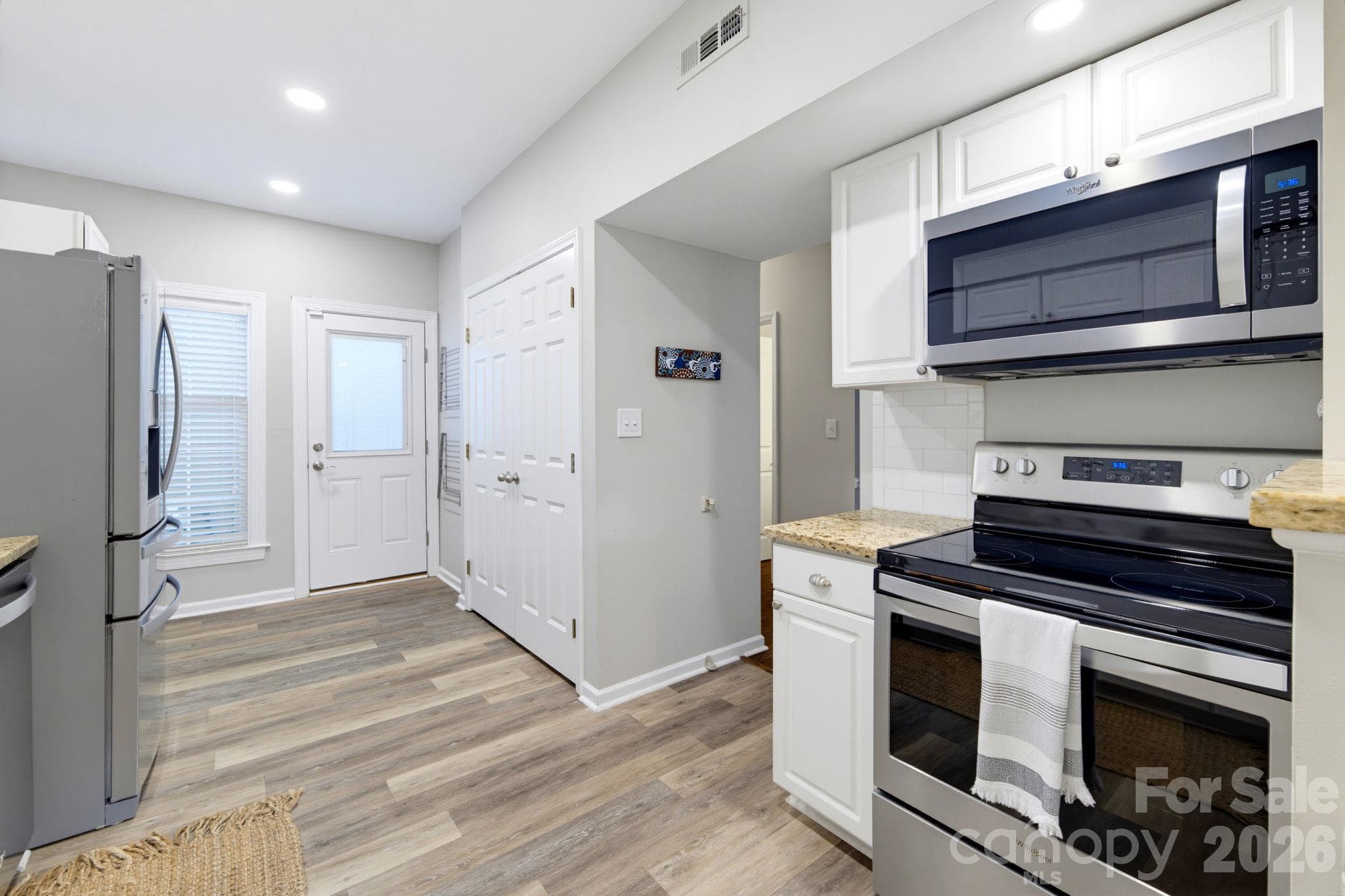 Galley style kitchen w/ access from the Dining & Living areas, enclosed laundry. Exterior door w/built-in blinds leads to the front patio and spacious storage room. - 5901 Quail Hollow Road, Charlotte