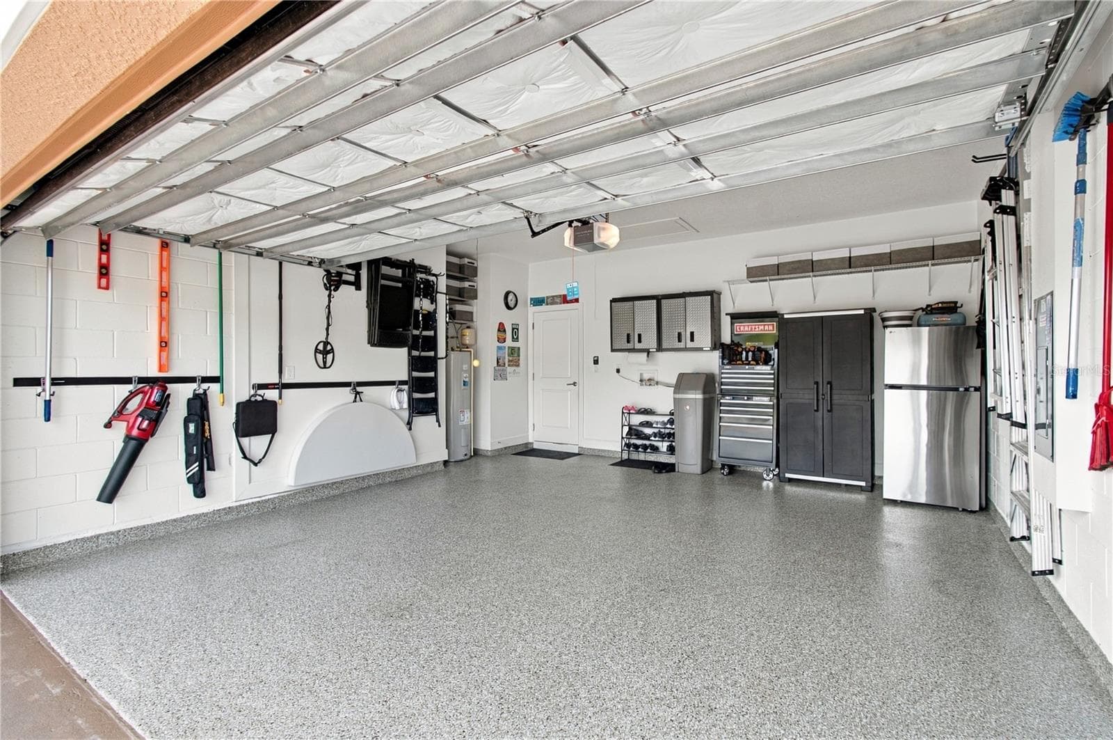 Garage w/shark coating floor, cabinets, refrigerator and tool racks - 1120 VIA GALUPPI ST, POINCIANA