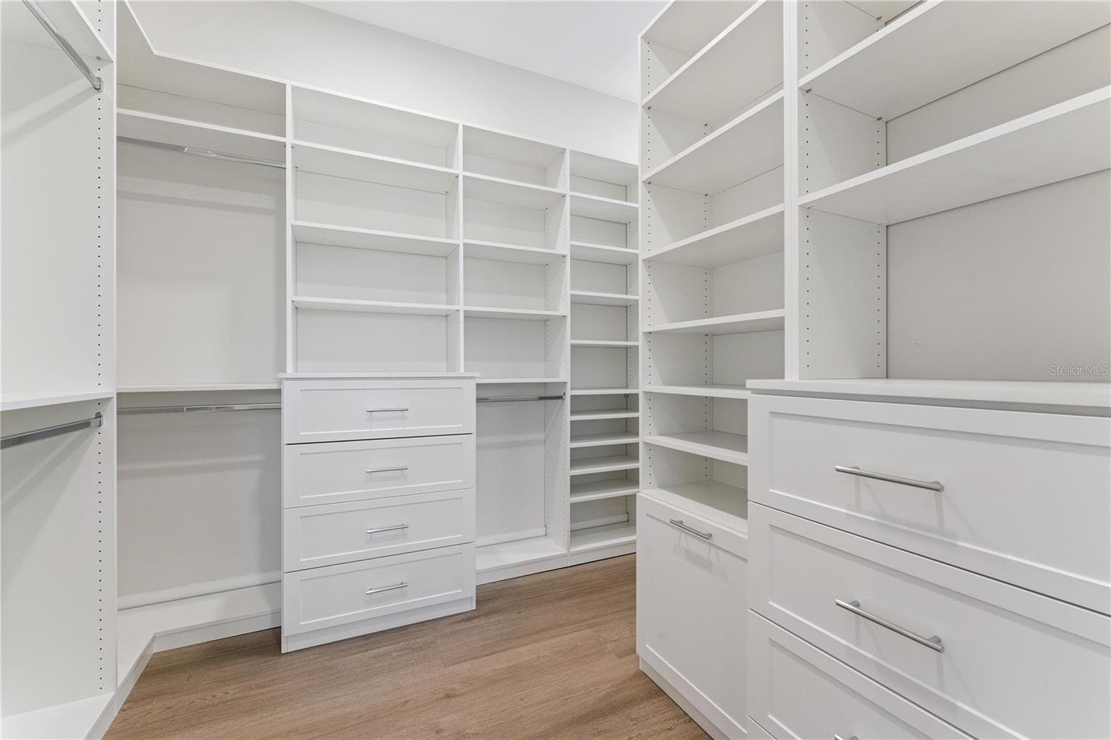 Built-in shelves, drawers, and hanging rods provide organized closet storage. - 3456 FAIRWAY LN, ORLANDO