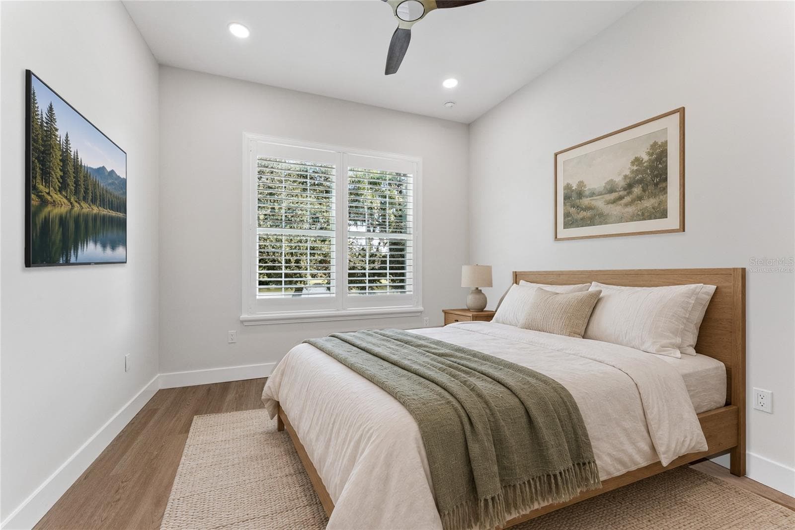 Virtually Staged - A shuttered window, ceiling fan, and light walls create a bright bedroom setting. - 3456 FAIRWAY LN, ORLANDO